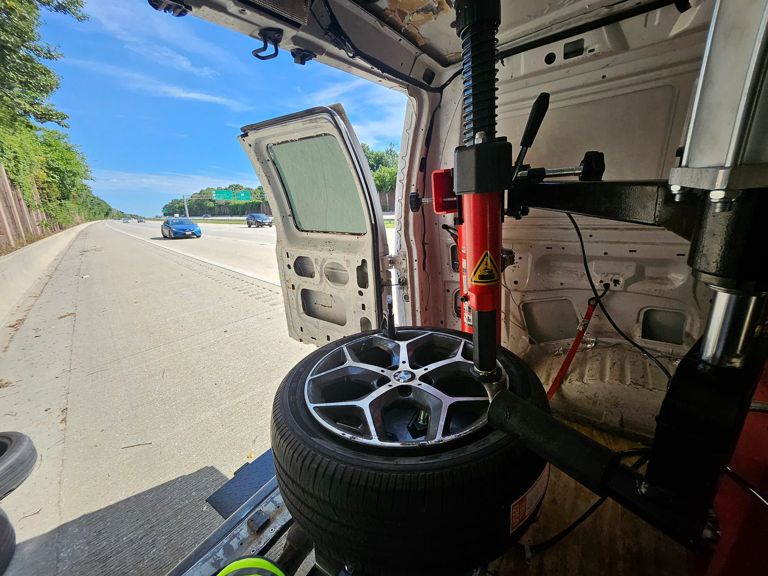 Changing a BMW tire on the side of the highway for a nurse who was on her way to work. Many BMW tires are low profile tires which feature stiffer sidewalls and are harder to mount and dismount. These tires are more prone to blowouts from potholes and curbs because their shorter sidewalls offer less cushion to absorb impacts. Low profile tires often require the use of helper arms on the tire machine to assist the tech lift the bead of the tire over the duck head during dismount.